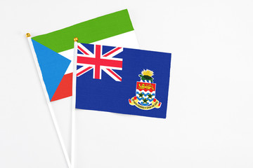 Fototapeta premium Cayman Islands and Equatorial Guinea stick flags on white background. High quality fabric, miniature national flag. Peaceful global concept.White floor for copy space.