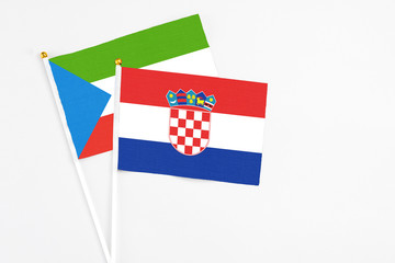 Croatia and Equatorial Guinea stick flags on white background. High quality fabric, miniature national flag. Peaceful global concept.White floor for copy space.