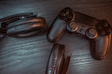 Gaming headphones and wireless controller, on a wooden table