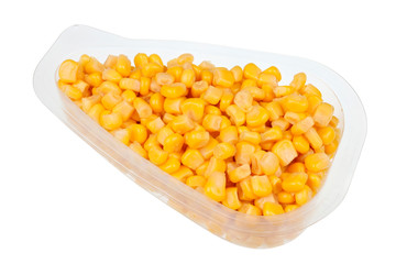 Daily food product - small marinated  sweet corn   in a transparent plastic container  isolated macro