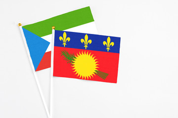 Guadeloupe and Equatorial Guinea stick flags on white background. High quality fabric, miniature national flag. Peaceful global concept.White floor for copy space.