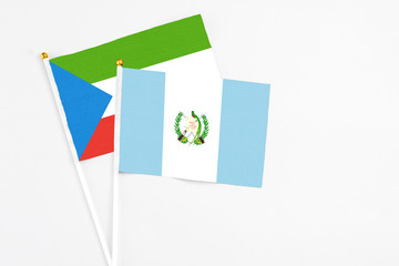 Guatemala and Equatorial Guinea stick flags on white background. High quality fabric, miniature national flag. Peaceful global concept.White floor for copy space.