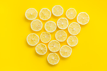 Lemon slices on yellow background top view