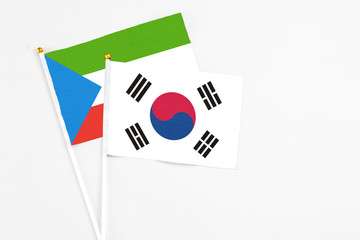 South Korea and Equatorial Guinea stick flags on white background. High quality fabric, miniature national flag. Peaceful global concept.White floor for copy space.