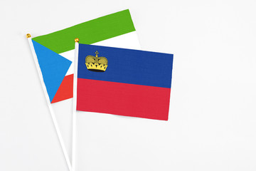 Liechtenstein and Equatorial Guinea stick flags on white background. High quality fabric, miniature national flag. Peaceful global concept.White floor for copy space.