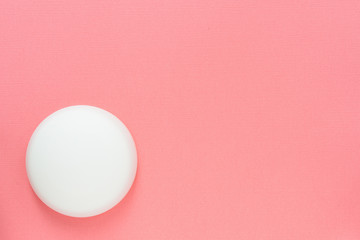 Top view with a cosmetic jar on a pink background. Health and beauty. Mockup with copyspace