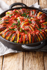 Vegetarian baked vegetable mix in tomato sauce close-up in a pan. vertical
