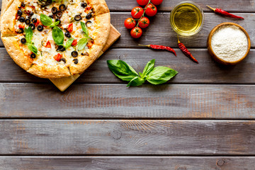 Traditional italian food: pizza on dark wooden background top view copy space