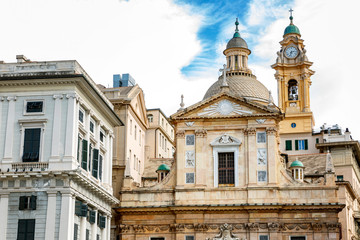 Fototapeta na wymiar Genoa, Italy, 10/04/2019: A beautiful temple of old architecture in the historic center of a European city against a bright blue sky.