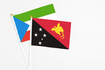 Papua New Guinea and Equatorial Guinea stick flags on white background. High quality fabric, miniature national flag. Peaceful global concept.White floor for copy space.