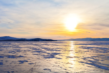 Fototapeta na wymiar Winter Baikal Lake. Beautiful sunset over the Small Sea Strait at March evening. Ice travel. Natural background