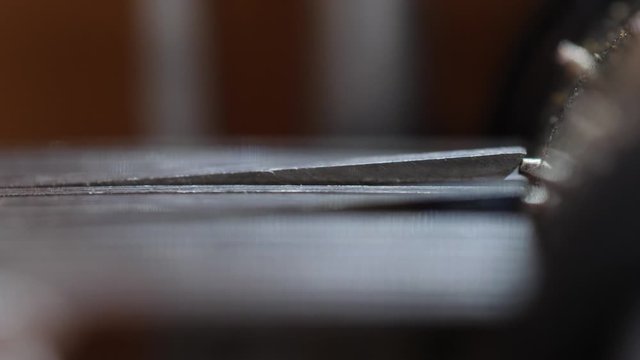 Macro close-up of the cylinder inside a music box as it rotates and raises the teeth to play music.