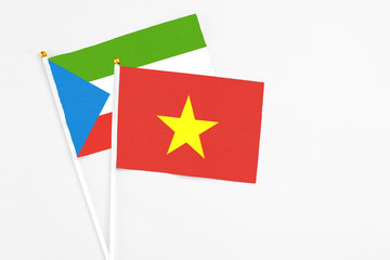 Vietnam and Equatorial Guinea stick flags on white background. High quality fabric, miniature national flag. Peaceful global concept.White floor for copy space.