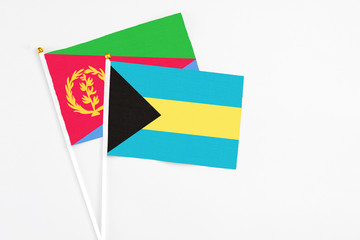 Bahamas and Eritrea stick flags on white background. High quality fabric, miniature national flag. Peaceful global concept.White floor for copy space.