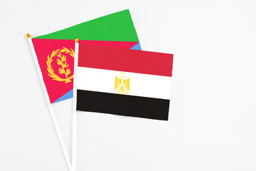 Egypt and Eritrea stick flags on white background. High quality fabric, miniature national flag. Peaceful global concept.White floor for copy space.