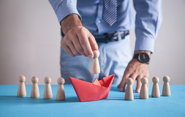 Man holding wooden human figure. Leader