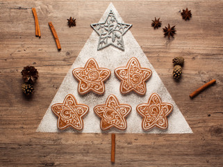 Christmas cookies and cookie cutters on wooden background. Christmas composition. Winter, new year concept. Flat lay, top view. Cones, cinnamon and coriander. 2020