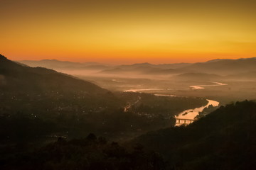 Mountain view morning above Kok river around with sea of mist, mountain and yellow light in the sky background, sunrise at Wat Tha Ton, Tha Ton, Fang, Chiang Mai, Thailand.