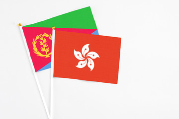 Hong Kong and Eritrea stick flags on white background. High quality fabric, miniature national flag. Peaceful global concept.White floor for copy space.