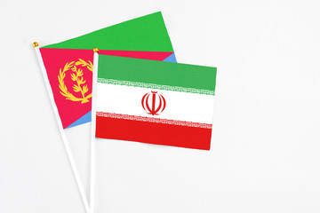 Iran and Eritrea stick flags on white background. High quality fabric, miniature national flag. Peaceful global concept.White floor for copy space.