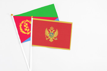 Montenegro and Eritrea stick flags on white background. High quality fabric, miniature national flag. Peaceful global concept.White floor for copy space.
