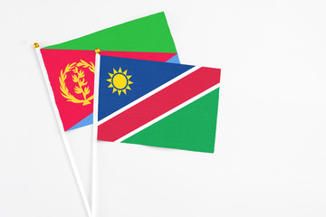 Namibia and Eritrea stick flags on white background. High quality fabric, miniature national flag. Peaceful global concept.White floor for copy space.