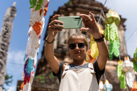 young woman taking a selfie in temple in Thailand, tourist