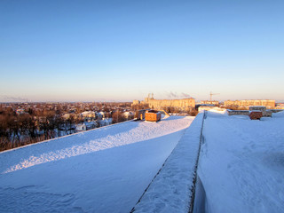 Winter dawn on the roof of an unfinished building. Panorama of the city.
