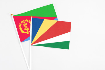 Seychelles and Eritrea stick flags on white background. High quality fabric, miniature national flag. Peaceful global concept.White floor for copy space.