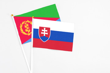 Slovakia and Eritrea stick flags on white background. High quality fabric, miniature national flag. Peaceful global concept.White floor for copy space.
