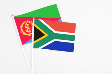 South Africa and Eritrea stick flags on white background. High quality fabric, miniature national flag. Peaceful global concept.White floor for copy space.