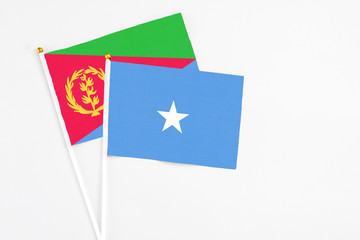 Somalia and Eritrea stick flags on white background. High quality fabric, miniature national flag. Peaceful global concept.White floor for copy space.