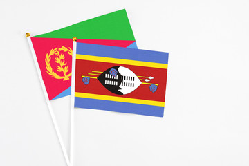 Swaziland and Eritrea stick flags on white background. High quality fabric, miniature national flag. Peaceful global concept.White floor for copy space.
