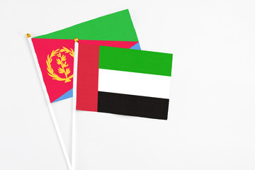 United Arab Emirates and Eritrea stick flags on white background. High quality fabric, miniature national flag. Peaceful global concept.White floor for copy space.