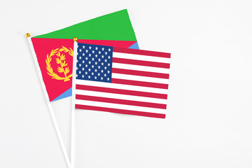 United States and Eritrea stick flags on white background. High quality fabric, miniature national flag. Peaceful global concept.White floor for copy space.