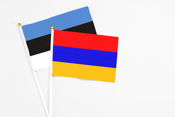 Armenia and Estonia stick flags on white background. High quality fabric, miniature national flag. Peaceful global concept.White floor for copy space.