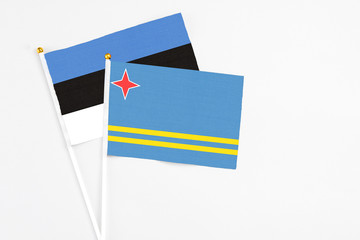 Aruba and Estonia stick flags on white background. High quality fabric, miniature national flag. Peaceful global concept.White floor for copy space.
