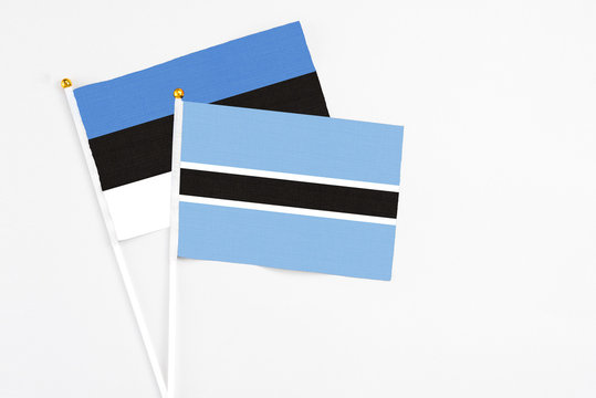 Botswana and Estonia stick flags on white background. High quality fabric, miniature national flag. Peaceful global concept.White floor for copy space.