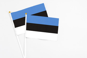 Estonia and Estonia stick flags on white background. High quality fabric, miniature national flag. Peaceful global concept.White floor for copy space.