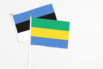 Gabon and Estonia stick flags on white background. High quality fabric, miniature national flag. Peaceful global concept.White floor for copy space.