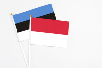 Indonesia and Estonia stick flags on white background. High quality fabric, miniature national flag. Peaceful global concept.White floor for copy space.