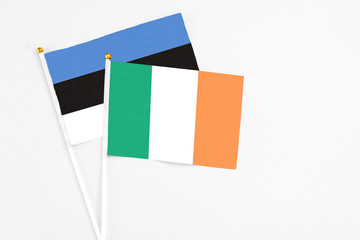 Ireland and Estonia stick flags on white background. High quality fabric, miniature national flag. Peaceful global concept.White floor for copy space.