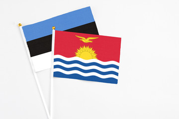 Kiribati and Estonia stick flags on white background. High quality fabric, miniature national flag. Peaceful global concept.White floor for copy space.