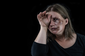 Crying woman victim of domestic violence and abuse. Isolated on dark background