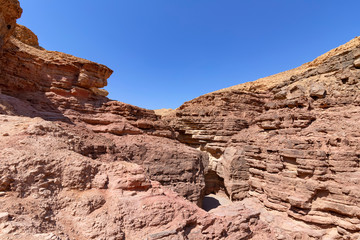 Obraz premium Spectacular layered surfaces of stone mountains in the Red Slot Canyon. Tourism Israel