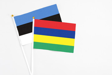 Mauritius and Estonia stick flags on white background. High quality fabric, miniature national flag. Peaceful global concept.White floor for copy space.