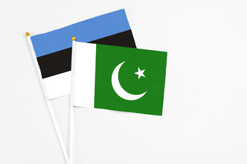 Pakistan and Estonia stick flags on white background. High quality fabric, miniature national flag. Peaceful global concept.White floor for copy space.