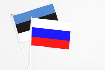Russia and Estonia stick flags on white background. High quality fabric, miniature national flag. Peaceful global concept.White floor for copy space.