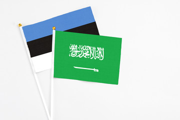 Saudi Arabia and Estonia stick flags on white background. High quality fabric, miniature national flag. Peaceful global concept.White floor for copy space.