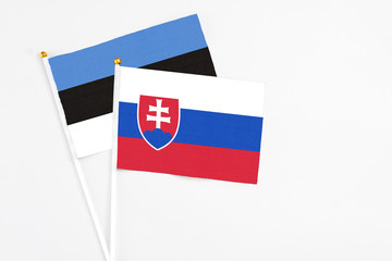Slovakia and Estonia stick flags on white background. High quality fabric, miniature national flag. Peaceful global concept.White floor for copy space.